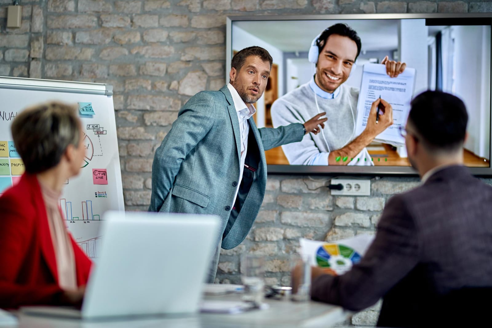 Team in ufficio durante una videochiamata con un collega